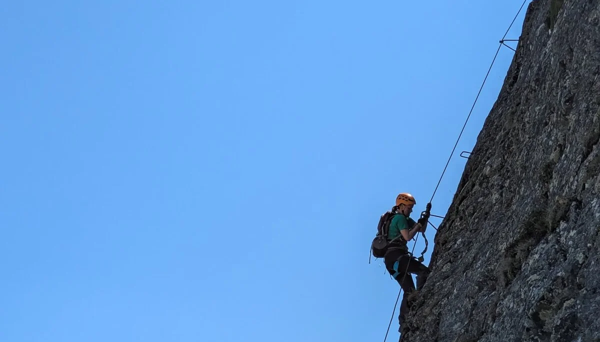 rechts felsige Wand an der zwei Männer mit Klettersteig-Ausrüstung hochklettern | © DAV Karlsruhe