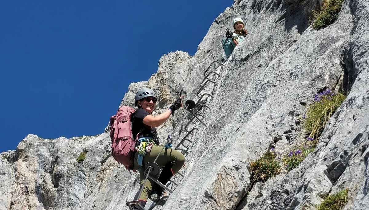 Foto von unten, wie zwei Personen Klettersteig-Tritte hochklettern | © DAV Karlsruhe