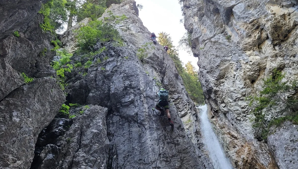 Foto von unten von Schlucht mit Wasserfall, Klettersteig Tritte an linker Seite  | © DAV Karlsruhe