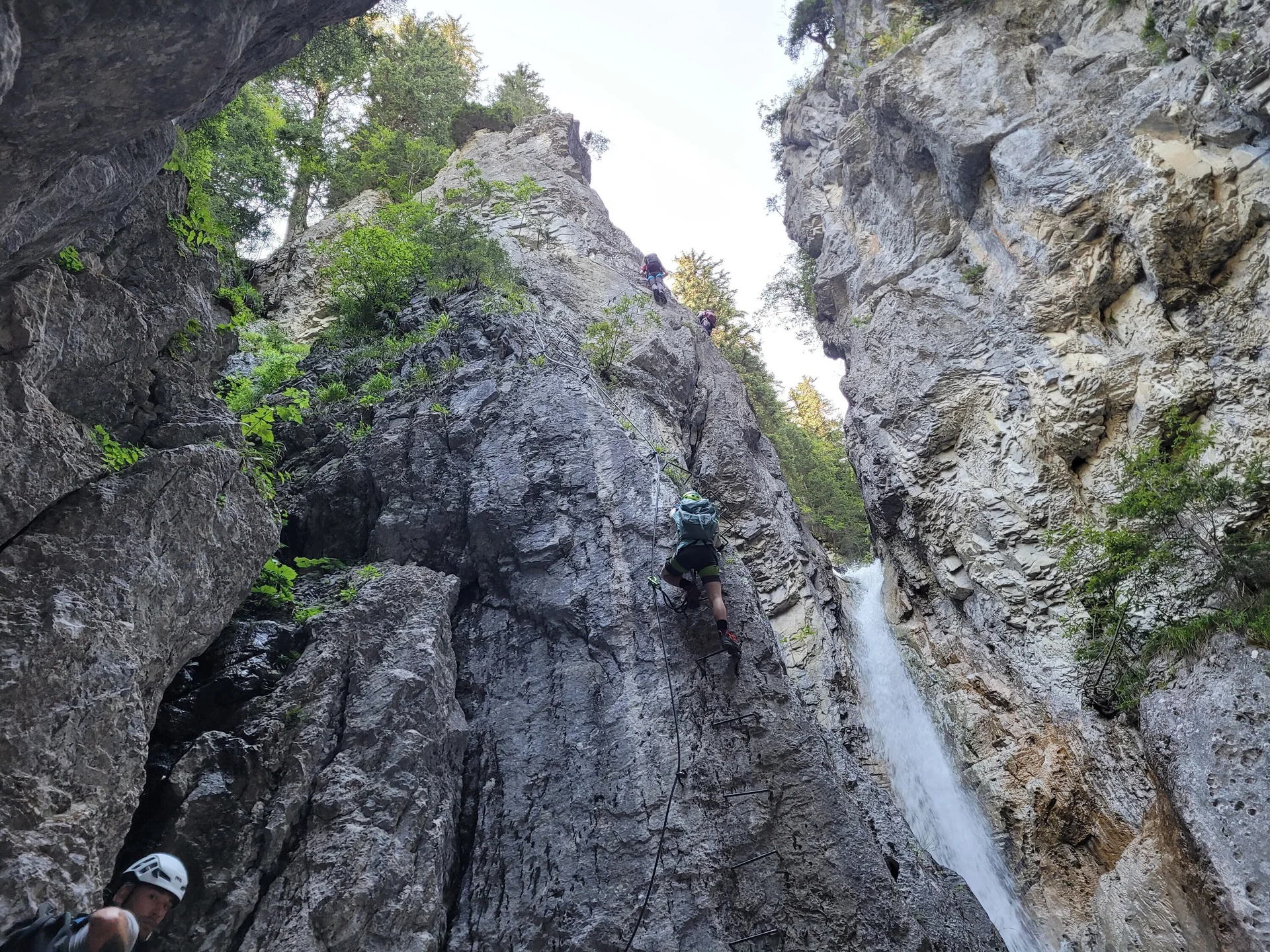 Foto von unten von Schlucht mit Wasserfall, Klettersteig Tritte an linker Seite  | © DAV Karlsruhe