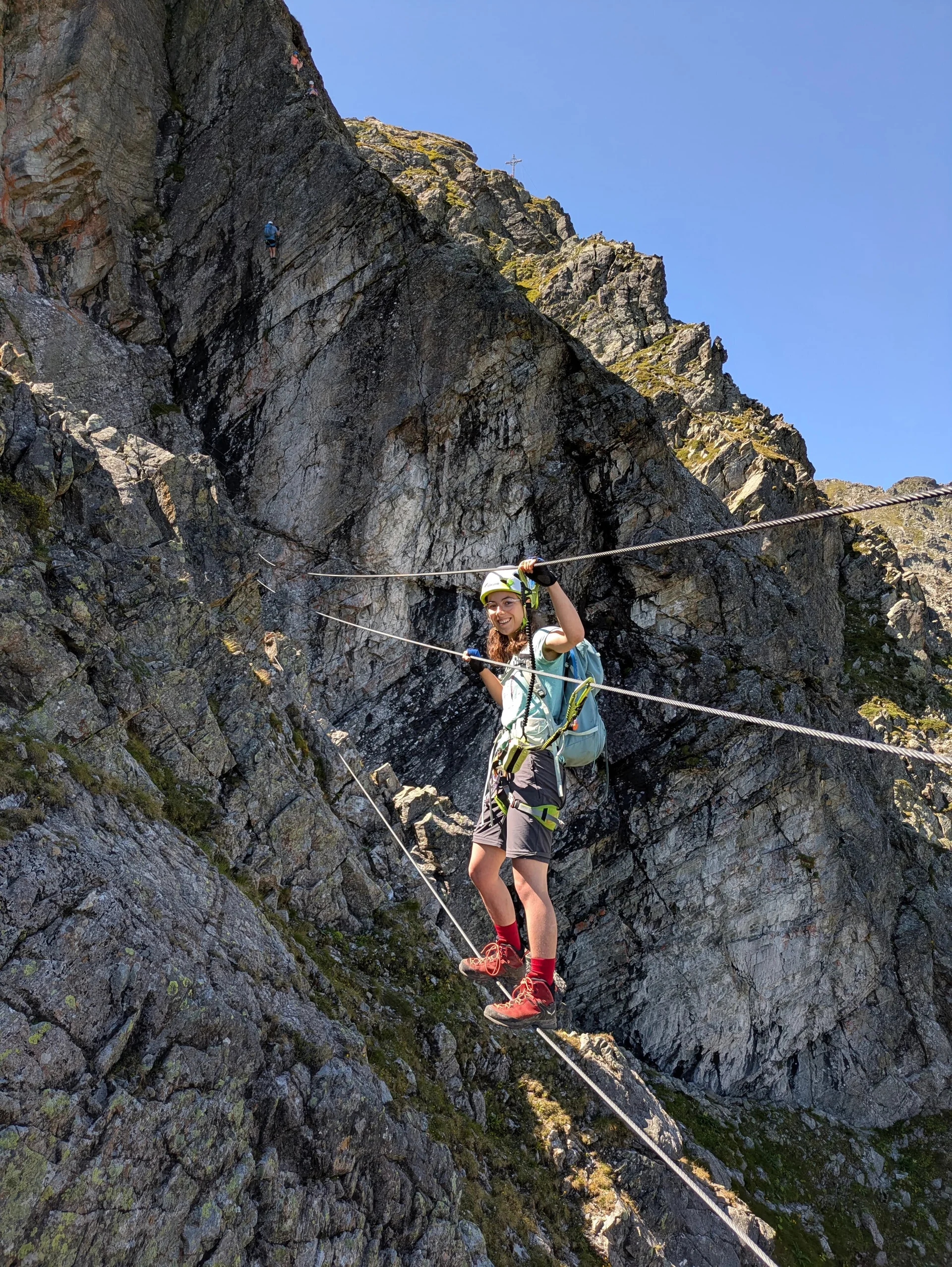 Junge Frau balanciert an Stahlseilen und mit Klettersteig-Set gesichert über kleine Schlucht | © DAV Karlsruhe
