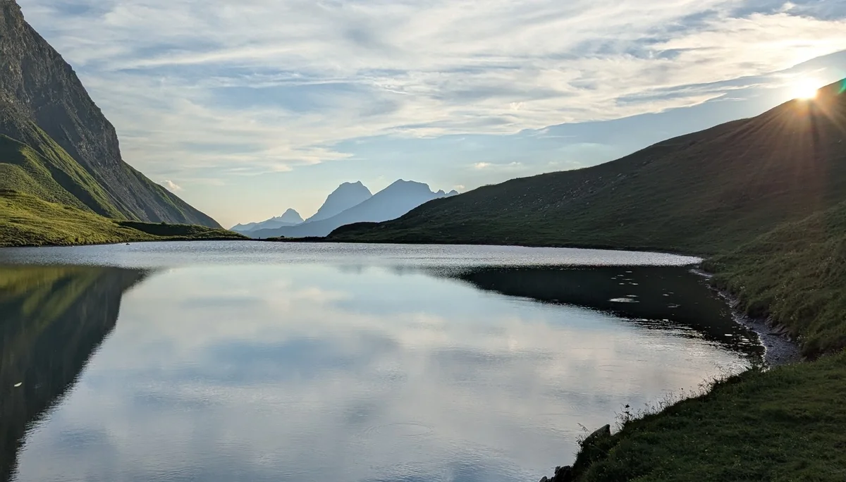 Spiegelnder See mit Bergen am Rand, tiefstehende Sonne | © DAV Karlsruhe