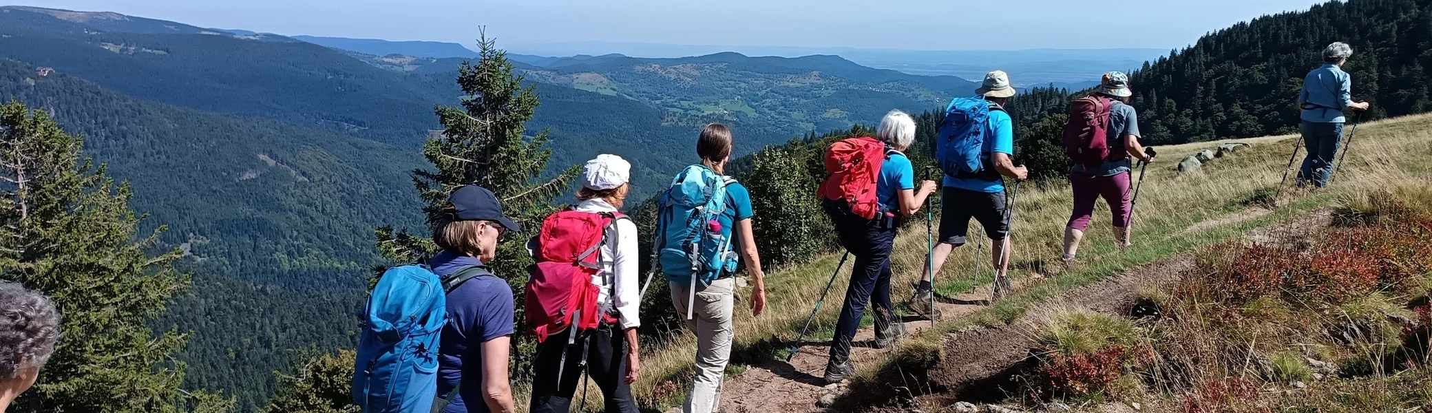 Wander:innen laufen vor hügeliger Kulisse und blauem Himmel | © DAV Karlsruhe